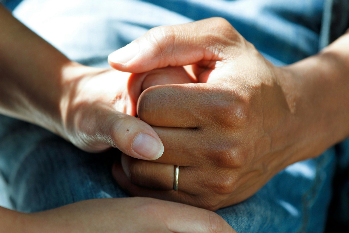 Two people holding hands, offering comfort