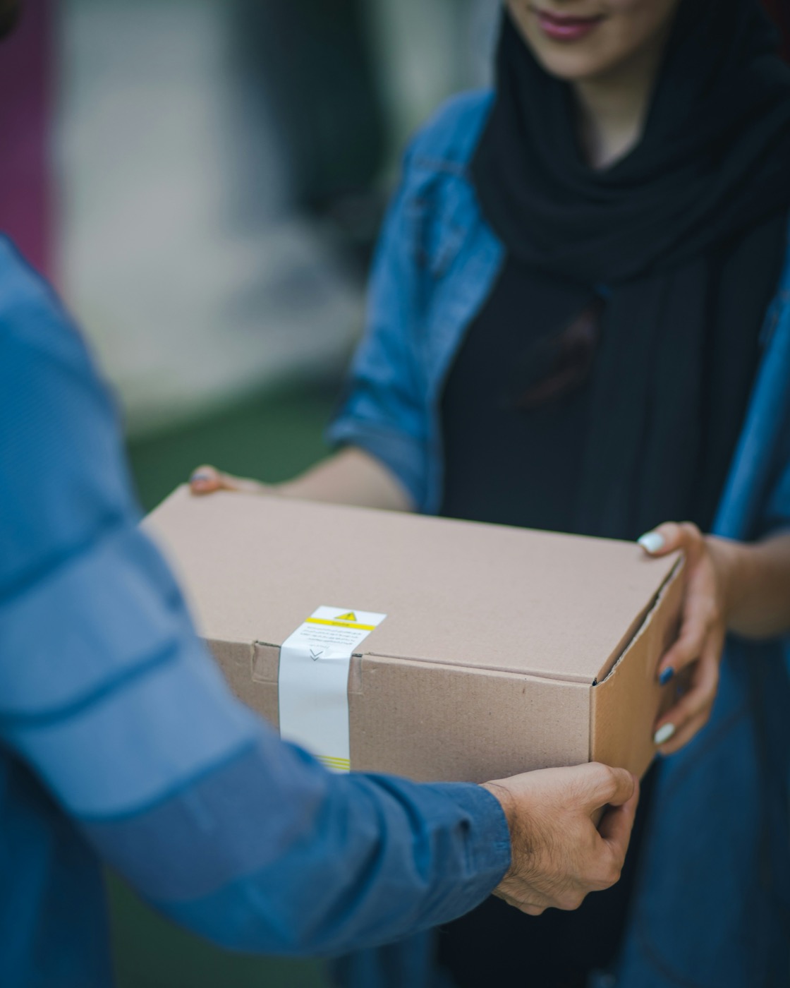 A box being carefully handed over between two people