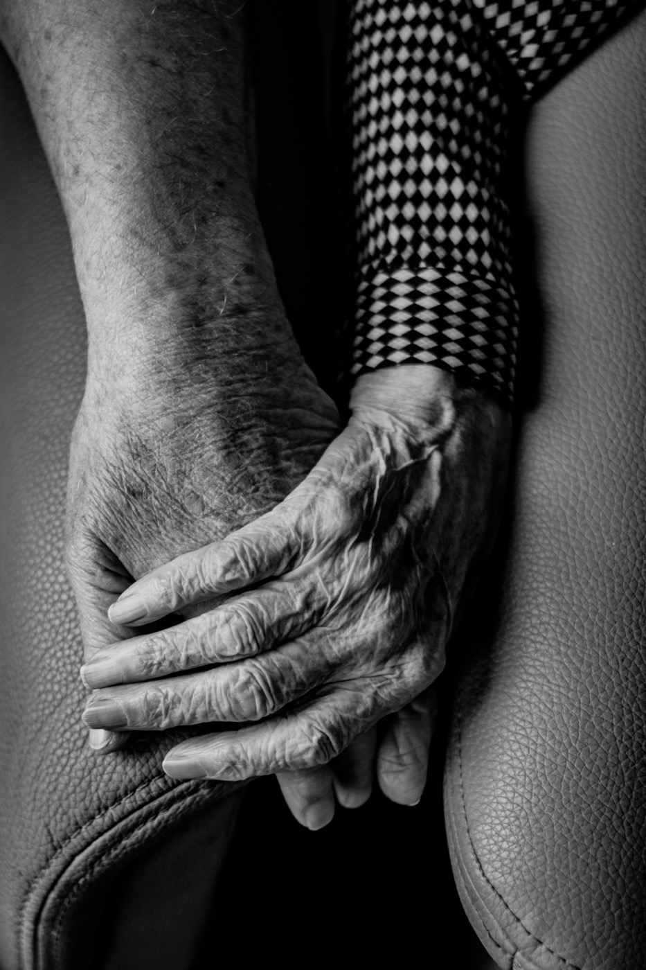 An elderly person's hands, resting calmly
